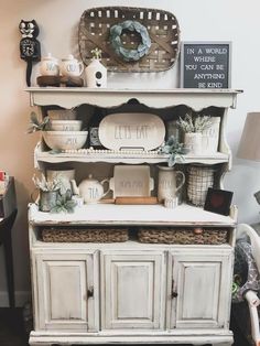 a white hutch with baskets and dishes on top