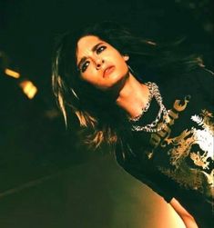 a woman with long hair standing in the dark