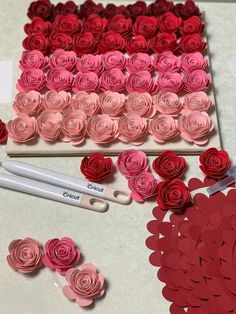 paper flowers and scissors on a table with cut out hearts for valentine's day