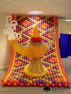 an art work made out of balloons and plastic balls in the shape of a trophy