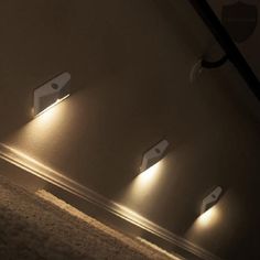 three lights that are on the side of a wall