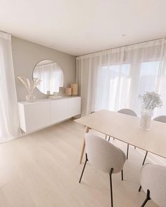 an instagram photo of a dining room with white chairs and a table in front of a large window