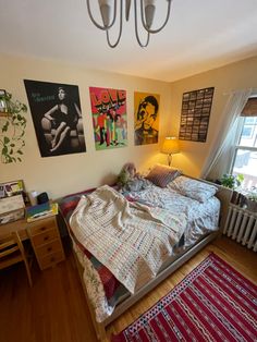 a bedroom with pictures on the wall and a bed in front of a window next to a radiator