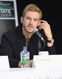 a man sitting at a table with a microphone