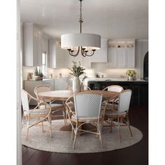 a dining room table with chairs and a chandelier hanging from the ceiling above it