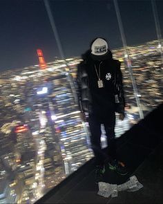 a man standing on top of a tall building in front of a cityscape