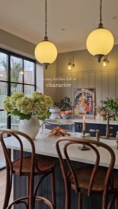 an image of a kitchen setting with flowers in vases on the counter and lights hanging from the ceiling