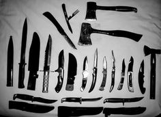 an assortment of knifes and knives laid out on a white sheet with black handles