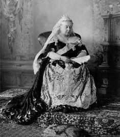 an old black and white photo of a woman sitting in a chair