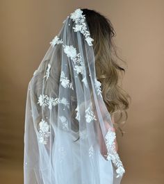 a woman wearing a veil with flowers on it