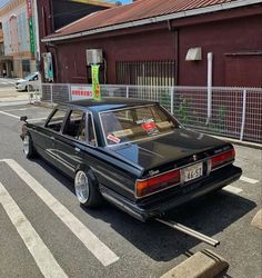 an old black car parked on the side of the road