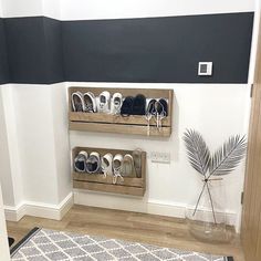 two wooden shelves holding pairs of shoes in a hallway