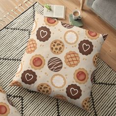 a floor pillow with cookies and hearts on it, next to a cup of coffee