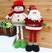 two christmas decorations sitting next to each other on top of a shelf in front of a wooden wall