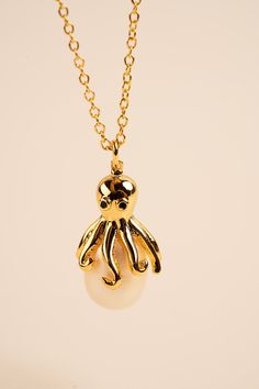 Our stunning Octopus Necklace features a beautifully crafted octopus pendant perched on top of a lustrous pearl. The intricate details of the octopus pendant capture the grace and beauty of these mysterious creatures, while the pearl adds a touch of elegance and sophistication. The pendant is suspended from a delicate chain, allowing it to rest perfectly on your neck. Crafted from high-quality materials, this necklace is both durable and comfortable to wear. It's perfect for any occasion, whether you're dressing up or keeping it casual. The Octopus Necklace with Pearl also makes a wonderful gift for anyone who loves sea creatures and ocean-inspired jewelry. It's a unique and thoughtful way to show someone you care. So why not add some nautical charm and elegance to your jewelry collection Sea Animals Jewelry, Sea Inspired Jewellery, Sea Themed Jewelry, Single Pearl Necklace Gold, Mysterious Creatures, Octopus Jewelry, Pearl Necklace Gold, Octopus Necklace, Octopus Pendant