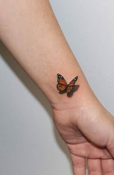 a woman's arm with a small butterfly tattoo on the left side of her wrist