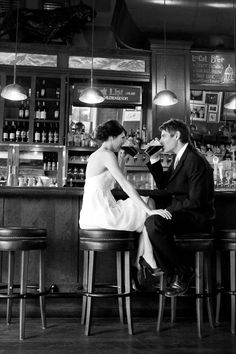 a man and woman sitting at a bar