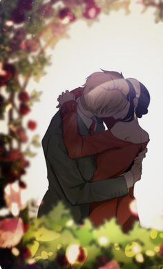 two people hugging each other in front of flowers