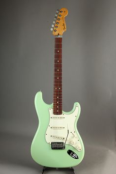 an electric guitar with a green body and neck