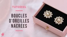 a pair of earrings in a pink box on top of a white sheet with the words boucles d'orelles nacres