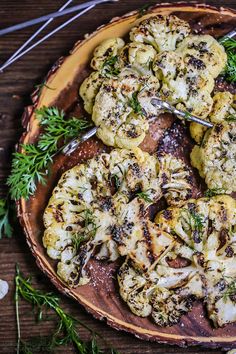 grilled cauliflower with herbs on a wooden platter