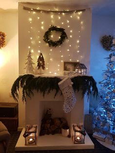 a decorated fireplace in a living room with christmas decorations on the mantle and lights around it