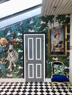a room with a chair and painting on the wall, next to a door that has a zebra painted on it