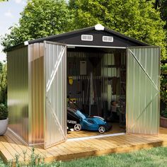 a small metal shed sitting on top of a wooden deck next to a potted plant