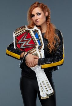 a woman with red hair holding a wrestling belt