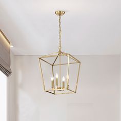 a chandelier hanging from the ceiling in a room with white walls and windows