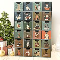 a christmas card with dogs and cats on it, surrounded by other holiday gifts in front of a tree