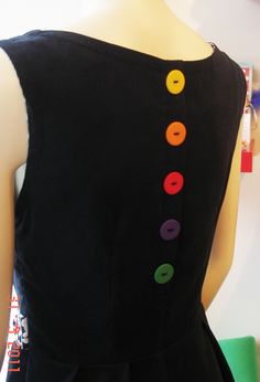 a black dress with multi colored buttons on it