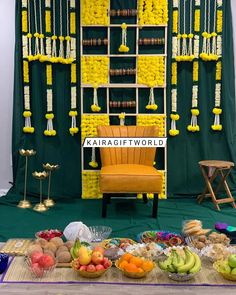 a yellow chair sitting in front of a display of fruits and other foods on a table