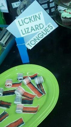 a green plate topped with cupcakes next to a sign that says lickin'lizard eggs