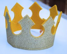 a gold glitter crown sitting on top of a white table