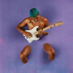 a man with green hair plays an electric guitar in front of his stomach and feet