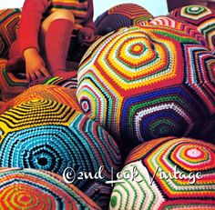 a little boy sitting on top of some colorful crocheted bean bag's