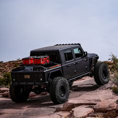 a black jeep parked on top of a rocky hill