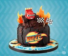 a birthday cake decorated with cars and flames