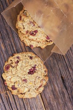 two oatmeal cookies sitting next to each other on top of a wooden table