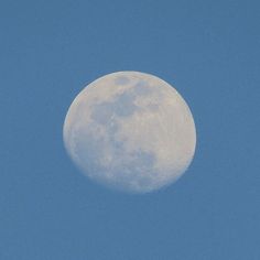 an airplane flying in the sky with a full moon behind it's back end