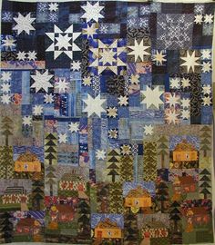 a quilted wall hanging with white stars and trees in the background on a table