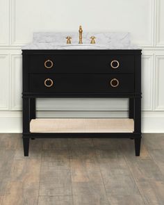 a bathroom vanity with marble top and gold faucets on the sink, against a white wall