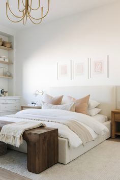 a bedroom with a bed, nightstands and a chandelier hanging from the ceiling