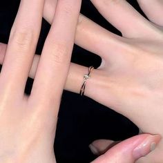 three hands are holding each other with their fingers together and one has a diamond ring on it