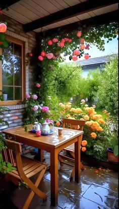 an outdoor table and chairs with flowers around it