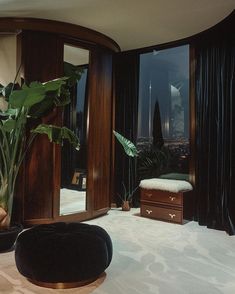 a living room filled with furniture and a large window covered in black curtained drapes