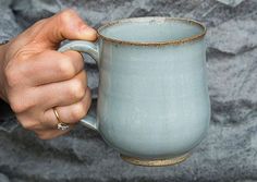 a person holding a coffee mug in their hand