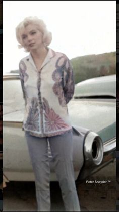 a woman standing next to a white car