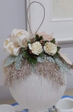 a white vase filled with flowers on top of a table